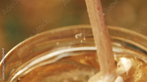 Wallpaper Mural Close-up detailed view of a beekeeper's hand stirring golden acacia honey in a glass jar at the apiary, showcasing the texture Torontodigital.ca