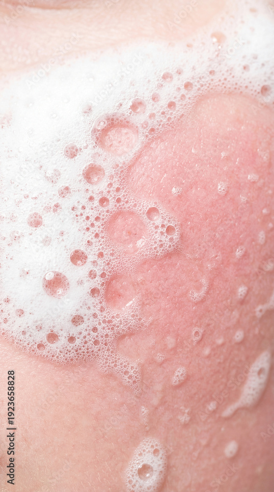 Fototapeta premium Bubbles rest on skin during bathing. Soft light highlights warm water and clean surroundings. Concept of personal care, hygiene, wellness products