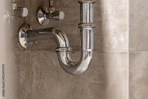 Foto Shiny chrome P-Trap and plumbing under a modern sink