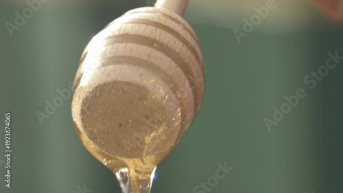 Wallpaper Mural Close-up detailed view of a beekeeper's hand stirring golden acacia honey in a glass jar at the apiary, showcasing the texture Torontodigital.ca