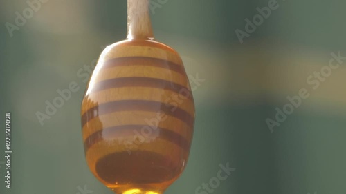 Wallpaper Mural Close-up detailed view of a beekeeper's hand stirring dark amber buckwheat honey in a glass jar at the apiary, showcasing the thick texture, Torontodigital.ca