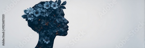 A silhouette of a person's profile filled with dark blue flowers and leaves, blending nature with human form in an artistic composition.