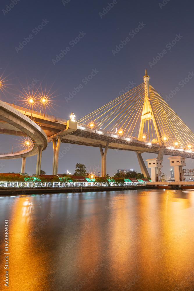 Fototapeta premium A view of a highway interchange and suspension bridges at twilight.