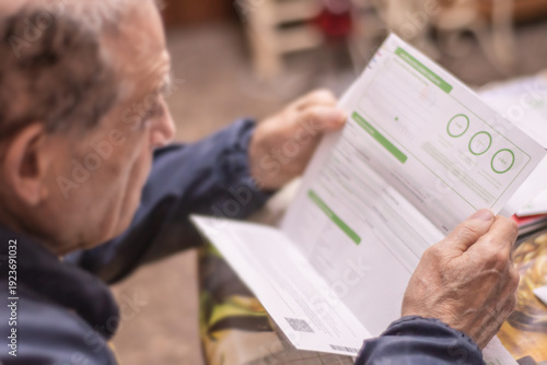 Foto An elderly man studies an electricity bill