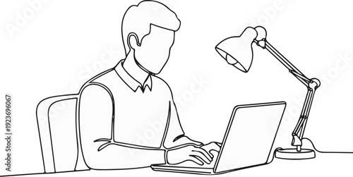 Person at desk typing on laptop, desk lamp illuminates workspace