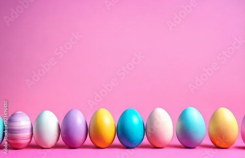 Row of easter painted eggs on pink background.