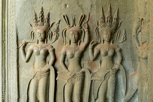 Cuadro en lienzo Intricate stone carving of three apsara dancers decorates the honor terrace at Angkor Vat, with ornate headdresses and elaborate jewelry highlighted by soft natural light