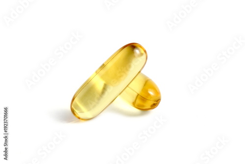 There are several vitamin D capsules on a white background.