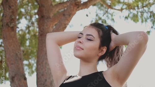 young woman relaxing under tree