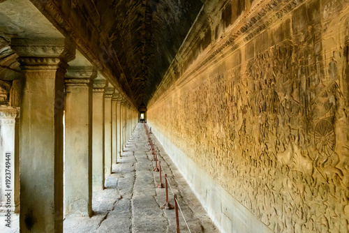 Bild auf Leinwand Long corridor lined with stone columns and intricate bas reliefs at Angkor Vat, Cambodia