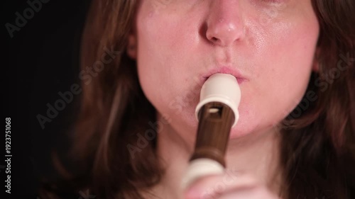 Close up of a woman playing a recorder. Music education and performance concept. Musical instrument art for sound design.