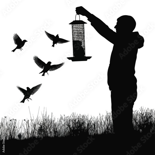 A silhouette of a person hanging a bird feeder with birds flying around it