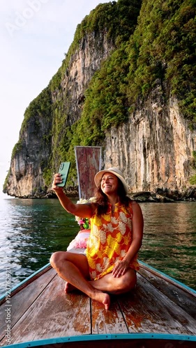 Woman taking selfie on a traditional longtail boat at Phi Phi Island