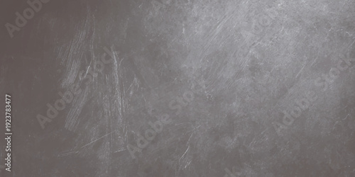 A blank vintage blackboard with chalk sits against a dark, textured grunge wall featuring an aged concrete stone pattern and a rough gray surface backdrop