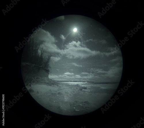 Authentic Night Vision View of a Coastal Landscape at Night Through a Real Gen 3 Image Intensifier Tube with Grain
