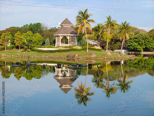 Slika na platnu Reflection of Gazebo Pavilion and Tropical Trees in a Green Lake Garden at  Shah Alam Lake Garden, Shah Alam , Selangor