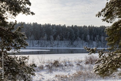 a wide river that is almost frozen in winter , a part of the river that is not frozen after severe frosts, the rest of the river is covered with ice and fresh snow