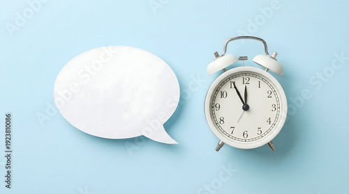 White Alarm Clock Next to Empty Speech Bubble on Blue Background