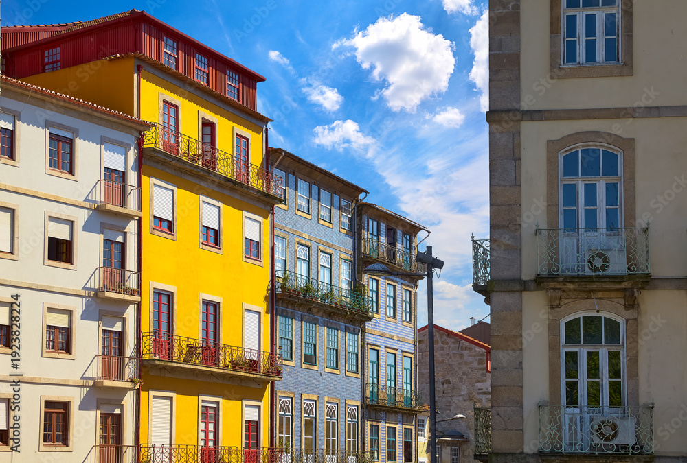 Fototapeta premium Porto, Portugal. Cosy street with traditional colorful houses. Windows and balconies. Sunny summer day. Residential porto city district with antique portugal buildings. Travel destination in Europe