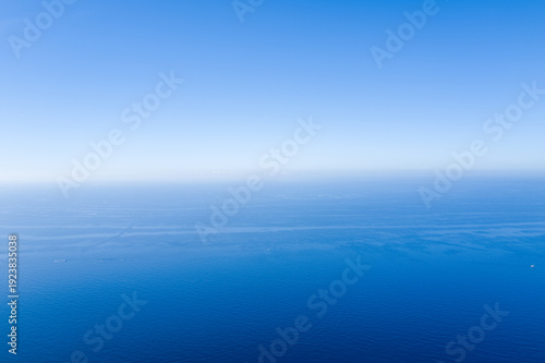 Foto Minimalist seascape with calm, deep blue Mediterranean water stretching to a clear sky, creating a tranquil and expansive atmosphere