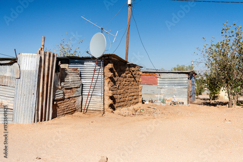 Home made from corrugated iron sheets, with a large satellite dish, in a township on the outskirts of Otjiwarongo, Namibia