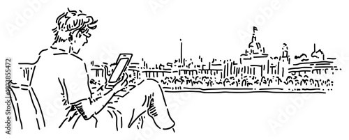 Young man sitting on a park bench using a smartphone with city skyline in background