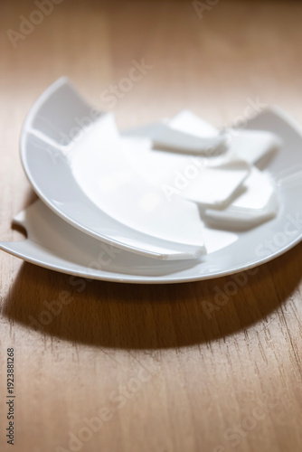 Broken plates stacked on a table after a meal in a kitchen setting during the afternoon
