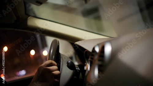 Wallpaper Mural Close up of a driver's hand holding a steering wheel inside a car at night Torontodigital.ca