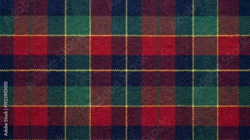 Rich red, green, blue, and yellow tartan fabric texture displays a classic Scottish plaid pattern for textile backgrounds. © Ghulam