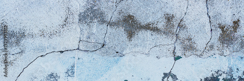 Vintage wall texture. Rough surface of the plastered concrete wall of the building. A pattern with many cracks and old faded peeling paint. Wide panoramic texture for background and design.