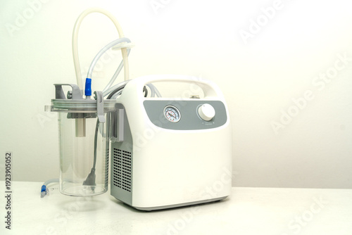Photos Portable Phlegm Suction on white background, Sputum suction machine from a tube in the throat of a patient who has undergone a tracheostomy surgery in hospital