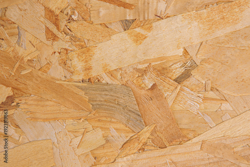 Eco-friendly OSB wood panel texture with recycled wood flakes. Natural chipboard pattern for furniture design, interior, and professional background use.