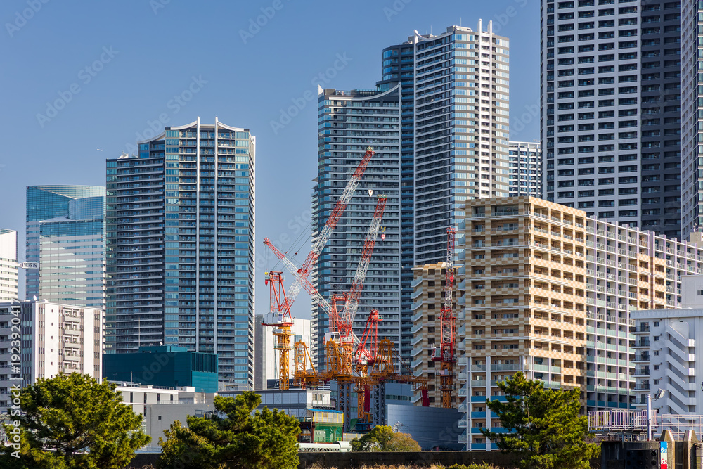 Fototapeta premium Modern high-rise apartment buildings and construction cranes in Tokyo, Japan