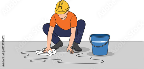 Construction worker wearing hard hat and safety gear cleaning up a liquid spill on a floor with a cloth and bucket.