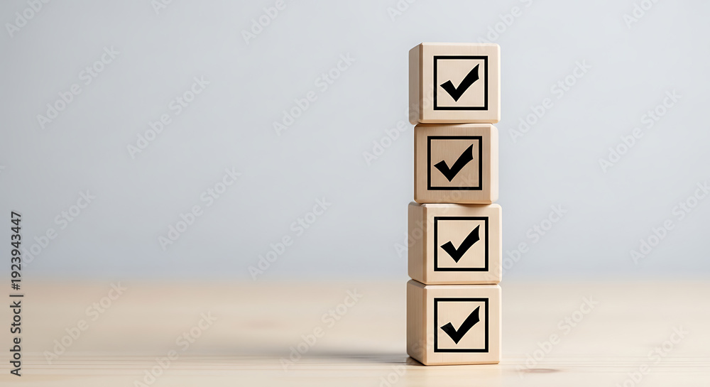 Fototapeta premium Four wooden blocks with checkmarks stacked vertically on a light surface with a plain background, symbolizing confirmation and approval.