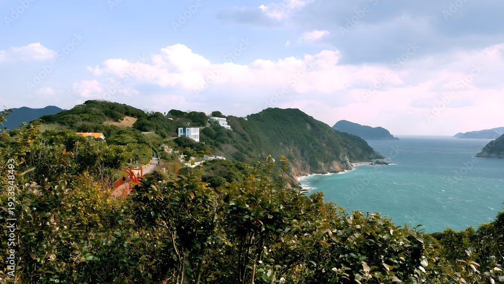Naklejka premium Scenic coastal landscape with turquoise sea and lush green cliffs.