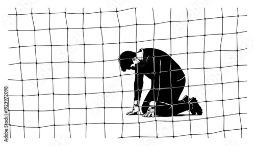Defeated goalkeeper kneeling in sadness inside the goal net after losing a game