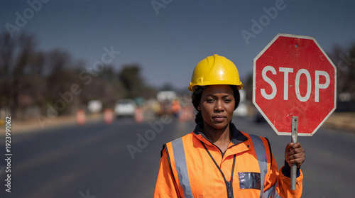 Wallpaper Mural Black female construction worker holding a stop sign on a road. Woman in safety vest and hard hat working in traffic control. Professional road maintenance worker Torontodigital.ca