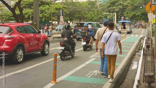 Urban men on busy street, two men strolling near lively road, casual walk through city park beside bustling street, two individuals walking leisurely along green cycle lane near busy city traffic