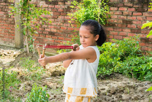 childhood concentration aiming target by traditional rural game wooden slingshot.
