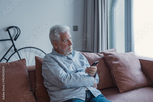 Worried senior smartphone user getting bad, concerning news message, holding mobile phone, looking away, feeling stressed, anxious, thinking over problems, sms answer 
