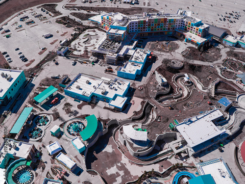 Aerial view of a bustling construction site with vibrant buildings and winding pathways, a symphony of industry and imagination, Frisco, Texas, United States.
