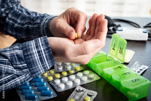 Tableau sur toile Middle aged caucasian man counts out pills for distributing scheduled dose of me