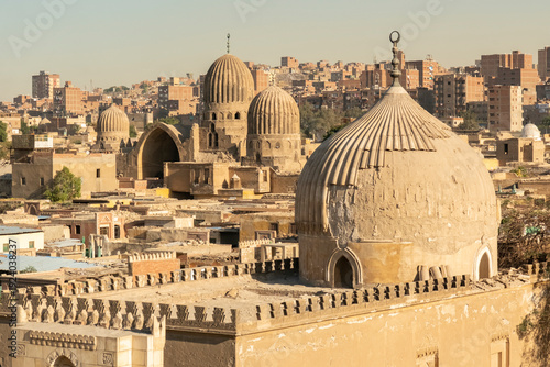 Historic buildings in Cairo with domes and minarets under a clear sky during the day