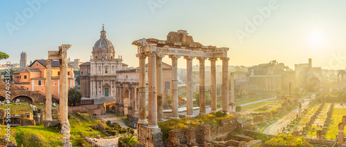 Panoramic view of Roman Forum at sunrise in Rome city, Italy. Ancient temple columns and ruins, historic churches and archaeological remains. Italian architecture. Popular touristic landmark