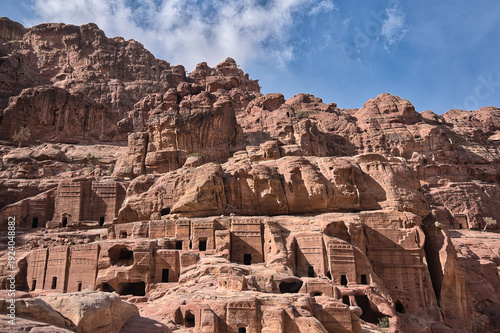 A wide view of the Street of Facades in the ancient city of Petra, Jordan. These impressive structures were carved directly into the red sandstone cliffs by the Nabataeans over 2,000 years ago