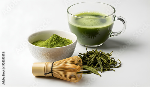 Image of Japanese matcha green tea with powdered green tea, loose leaves, and bamboo whisk on a white background. Represents healthy lifestyle, traditional tea culture, and minimalist food photography