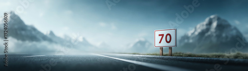 Low angle highway scene with speed limit sign, empty road mountain landscape, misty atmosphere, and dramatic sky