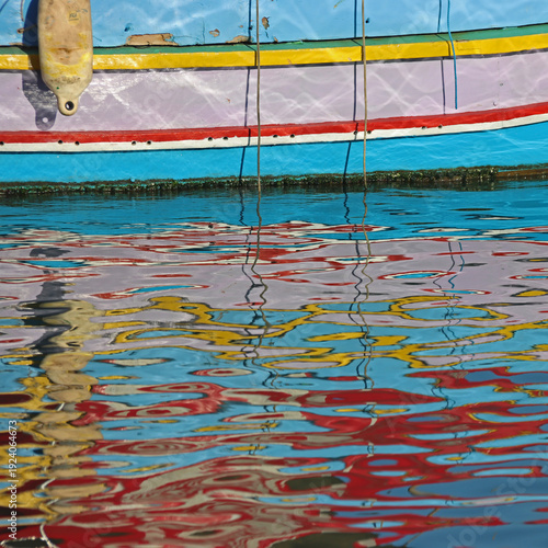 Colourful reflections of a fishing boat in the water