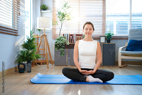 Free Download Young sporty woman does yoga on mat at home. Healthy lifestyle. Sport wellness people lifestyle concept - GFXLoad